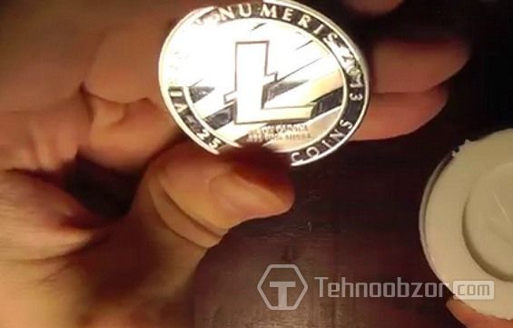 Монета Litecoin затиснута між пальцями