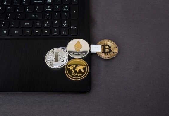 Монети декількох криптовалюта лежать на ноутбуці